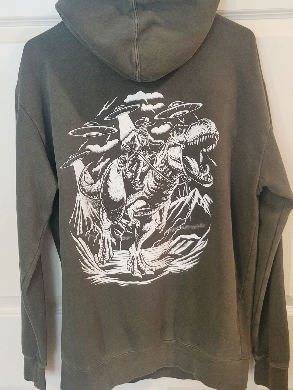 Cove - Olive Green Hoodie - Skeleton Cowboy Out-Running UFOs on a T-Rex